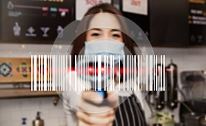 Business woman working in a coffee shop showing a modern barcode scanner.
