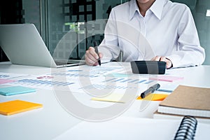 Business woman working at desk using laptop computer with documents and stationery supplies in office. Professional worker