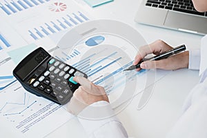 Business woman working at desk using laptop computer with documents and stationery supplies in office. Professional worker