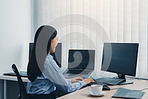 Business woman working on desktop computer monitor professional and sitting at her office desk and working on new software program