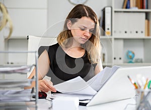 Business woman working with documents and laptop in office