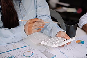 Business woman working in finance and accounting Analyze financial budget with calculator. work from home concept.