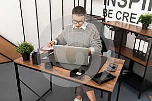 Business woman working in glasses at a laptop in the office