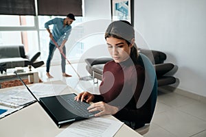 Business Woman Working At Home And Man Doing Chores