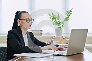 Business woman working in home office at desk with laptop computer