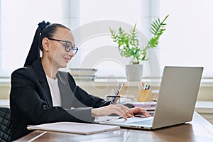 Business woman working in home office at desk with laptop computer