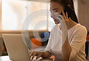 A business woman working at home, on the phone and computer