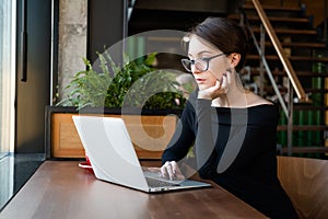 Business woman working on laptop in cafe. Distance job and remote work concept