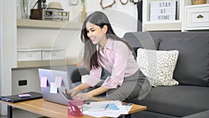 Business woman is working with laptop computer and analyzing business growth graph data in living room, Work from home ,