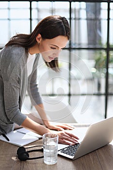 Business woman working on laptop computer in office photo