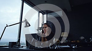 Business woman working on laptop. Female worker looking at graphics on document