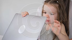 Business woman working on laptop at home with child. The child interferes with the mother's work