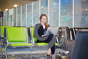 Business woman working on laptop in international airport