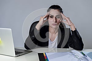 Business woman working on laptop at office in stress suffering intense headache migraine