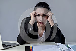 Business woman working on laptop at office in stress suffering intense headache migraine