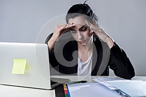 Business woman working on laptop at office in stress suffering intense headache migraine