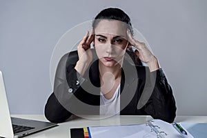 Business woman working on laptop at office in stress suffering intense headache migraine