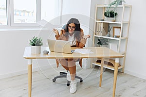 Business woman working in office at desk with laptop, anger and argument, discussing business processes online via video