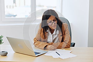 Business woman working in office at desk with laptop, anger and argument, discussing business processes online via video