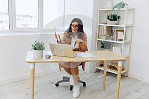 Business woman working in office at desk with laptop, anger and argument, discussing business processes online via video