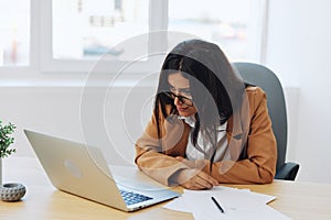 Business woman working in office at desk with laptop, anger and argument, discussing business processes online via video