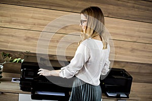 Business woman working in office by the printer