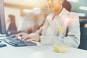 Business Woman Working race against time with Times Hourglass on Desk Clock for Office Working Hours Concept