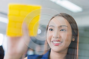 Business woman working and use post it notes to share idea on the glass board in office. Lifestyle business meeting concept.