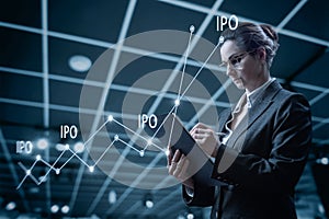 Businesswoman working on virtual computer with graph and IPO points photo