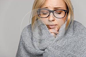 Business woman wrapped in warm scarf, feels bad, has flu