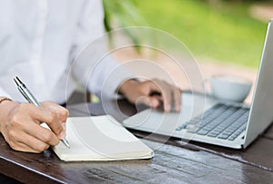 Business woman write on notebook outdoor in coffee shop.