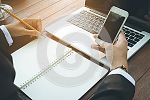 Business woman write on notebook and use telephone working outdoor in coffee shop