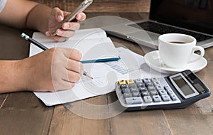 Business woman writing and analyzing graphs on work table