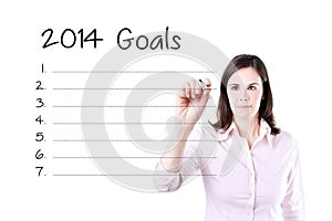 Business woman writing blank 2014 goals list.