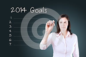 Business woman writing blank 2014 goals list. Blue background.
