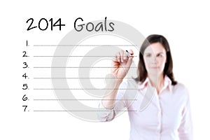 Business woman writing blank 2014 goals list. Isolated on white.