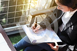 Business woman writing on clipboard outside on terrace,on top view.