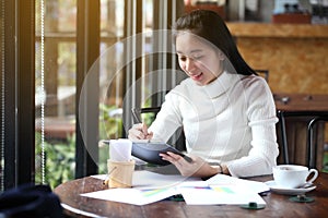 Business woman writing on clipboard outside on terrace.