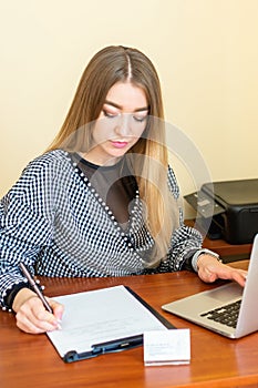 Business woman is writing on a document