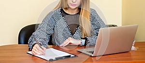 Business woman is writing on a document