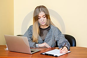 Business woman is writing on a document