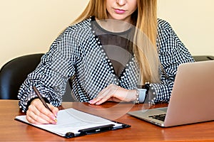 Business woman is writing on a document