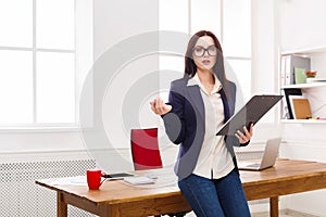 Business woman writing down notes at office