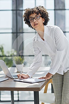 business woman writing at her desk in a modern office