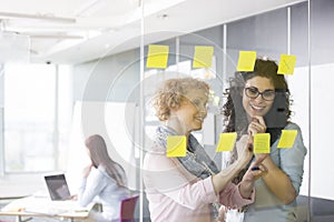Business women brainstorming with sticky notes in office photo