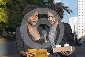 Business women with coffee and envelope in hands