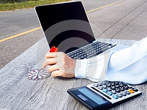 Business women hand point dart to bullseye with calculator and laptop on the road background