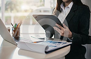 Business women hand working with tablet and laptop computer with documents on office desk