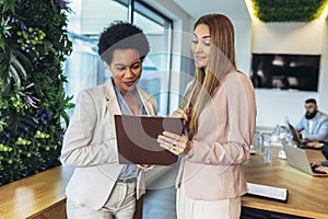 Business women having a discussion, they\'re standing in the office