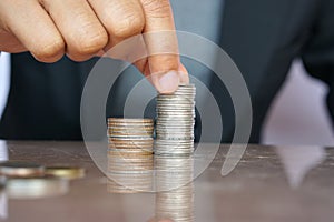 Business women put coin stack money for growth concept, save money for the future